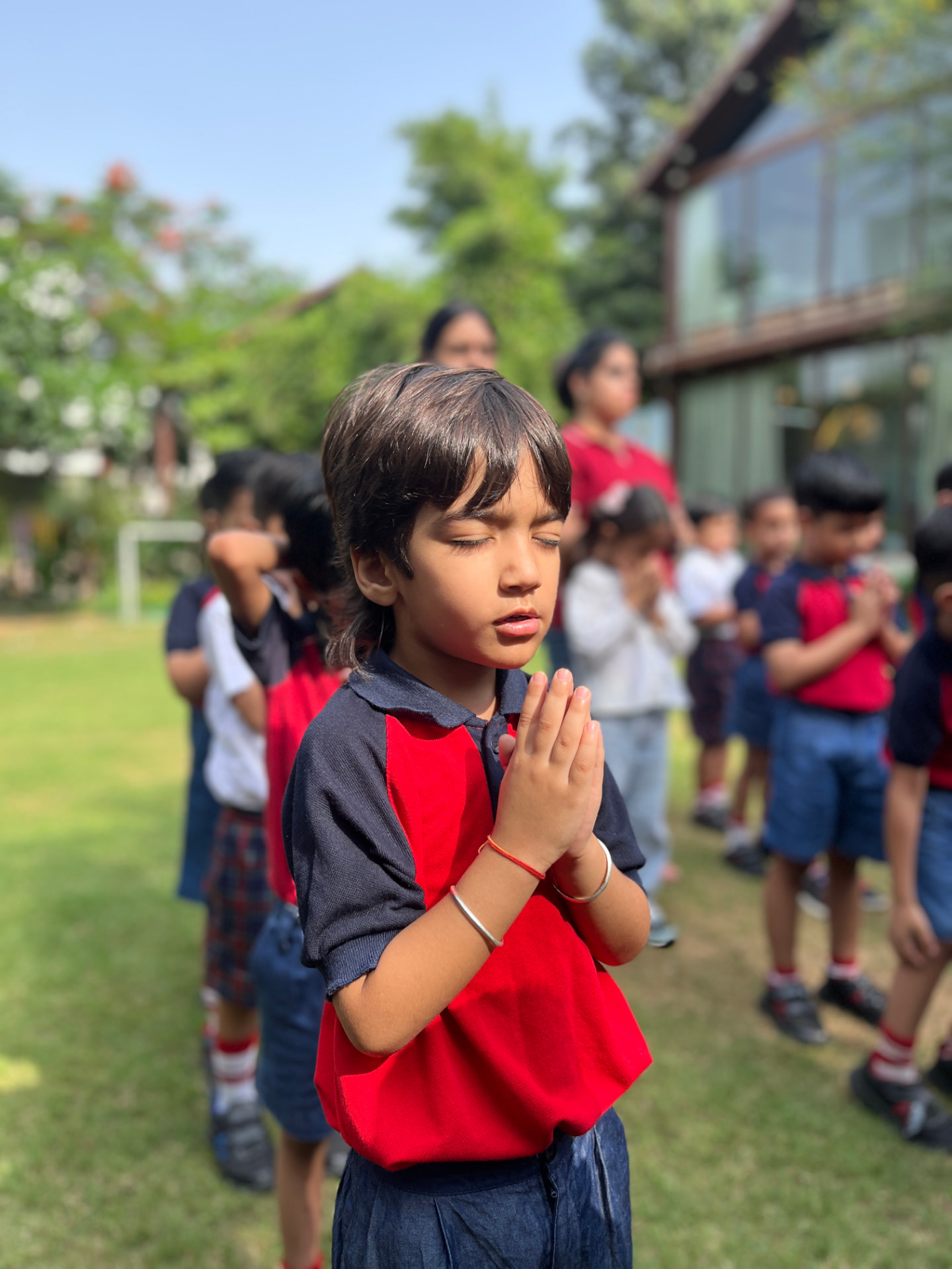 Children at morning prayer assembly on the school lawn
