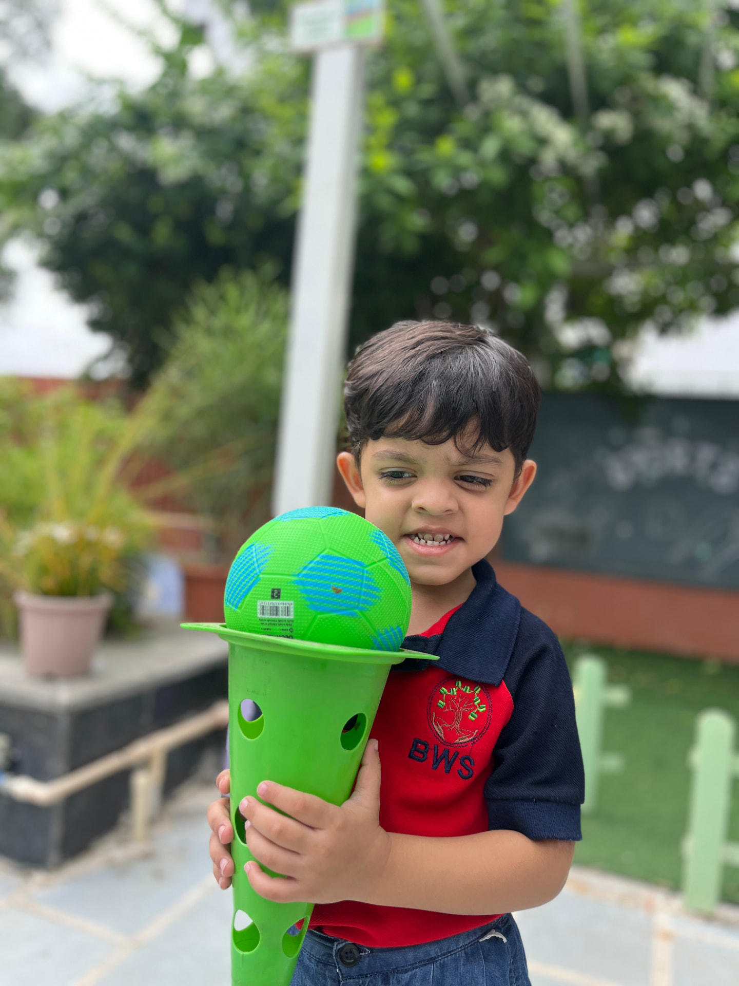 A young student playing with a ball in the school playground